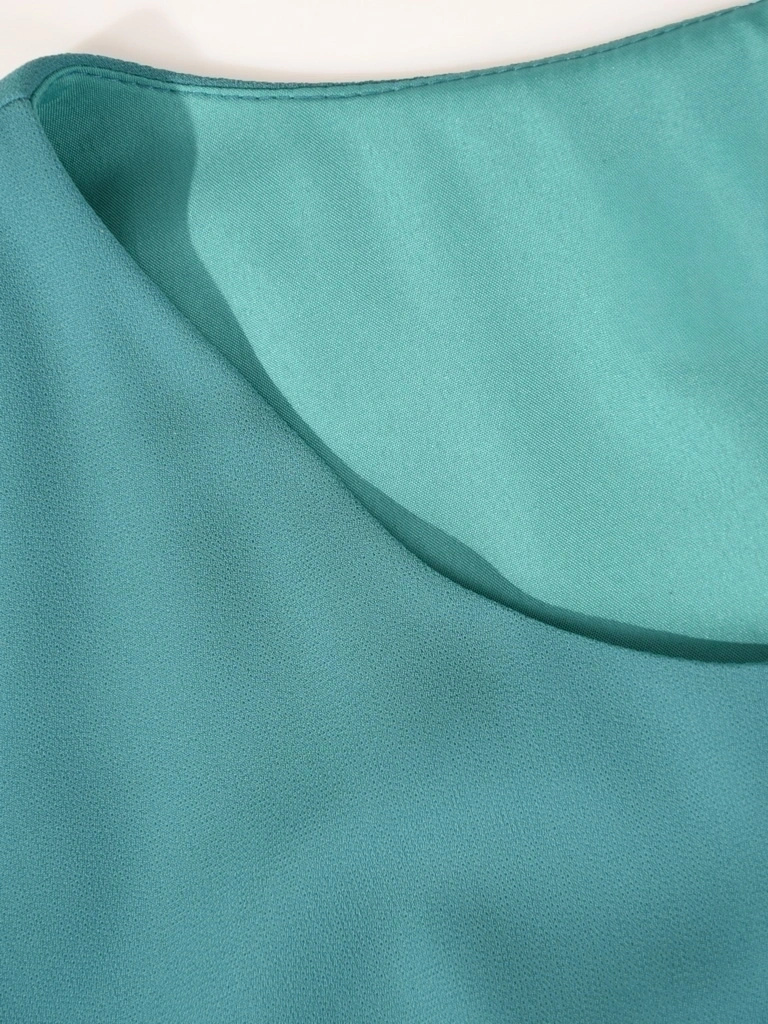 Elegancka sukienka trapezowa w kolorze szmaragdowym – zwiewny fason tuszujący biodra 41594